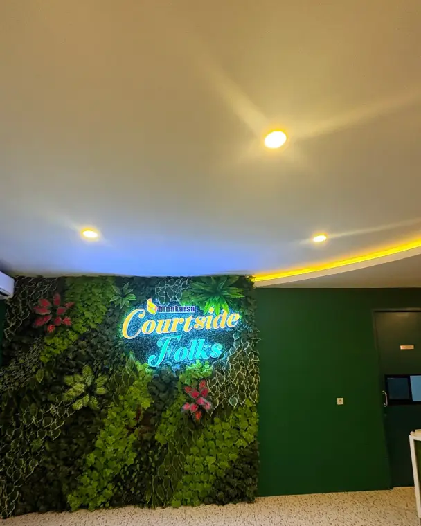 Neon Courtside Folks sign on a green wall